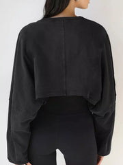 Back view of a black cropped sweatshirt with long sleeves.