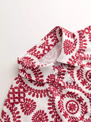 Women's printed tie-waist button-front romper, close-up of red printed fabric