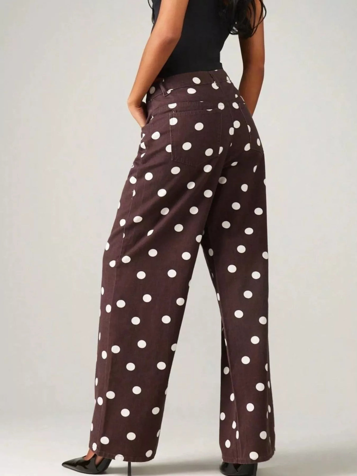 Brown polka-dot pants styled with black top and fuzzy jacket