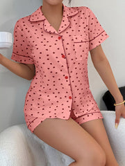 Model seated wearing pink heart-print short-sleeve pajama set