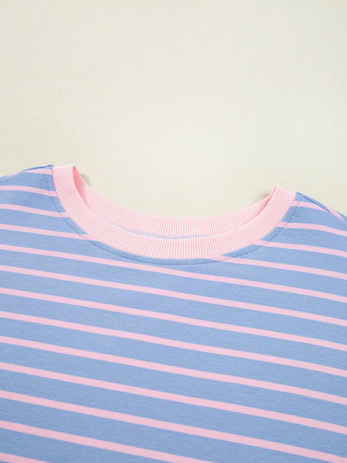Close-up of pink crew neckline and blue stripes