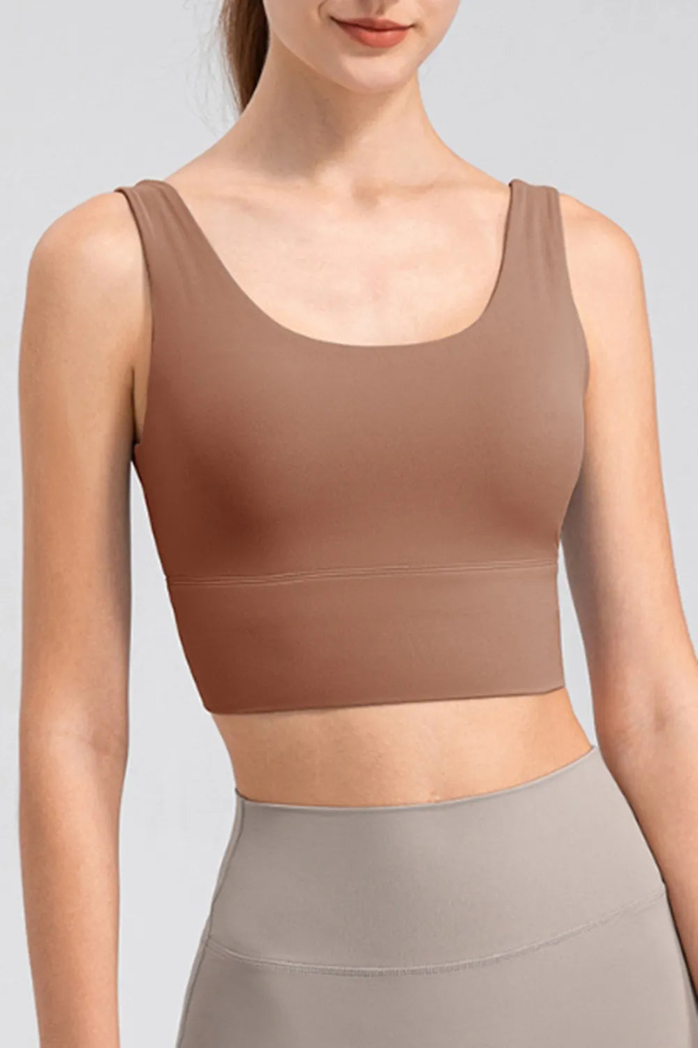 Model wearing the brown scoop-neck tank with taupe leggings