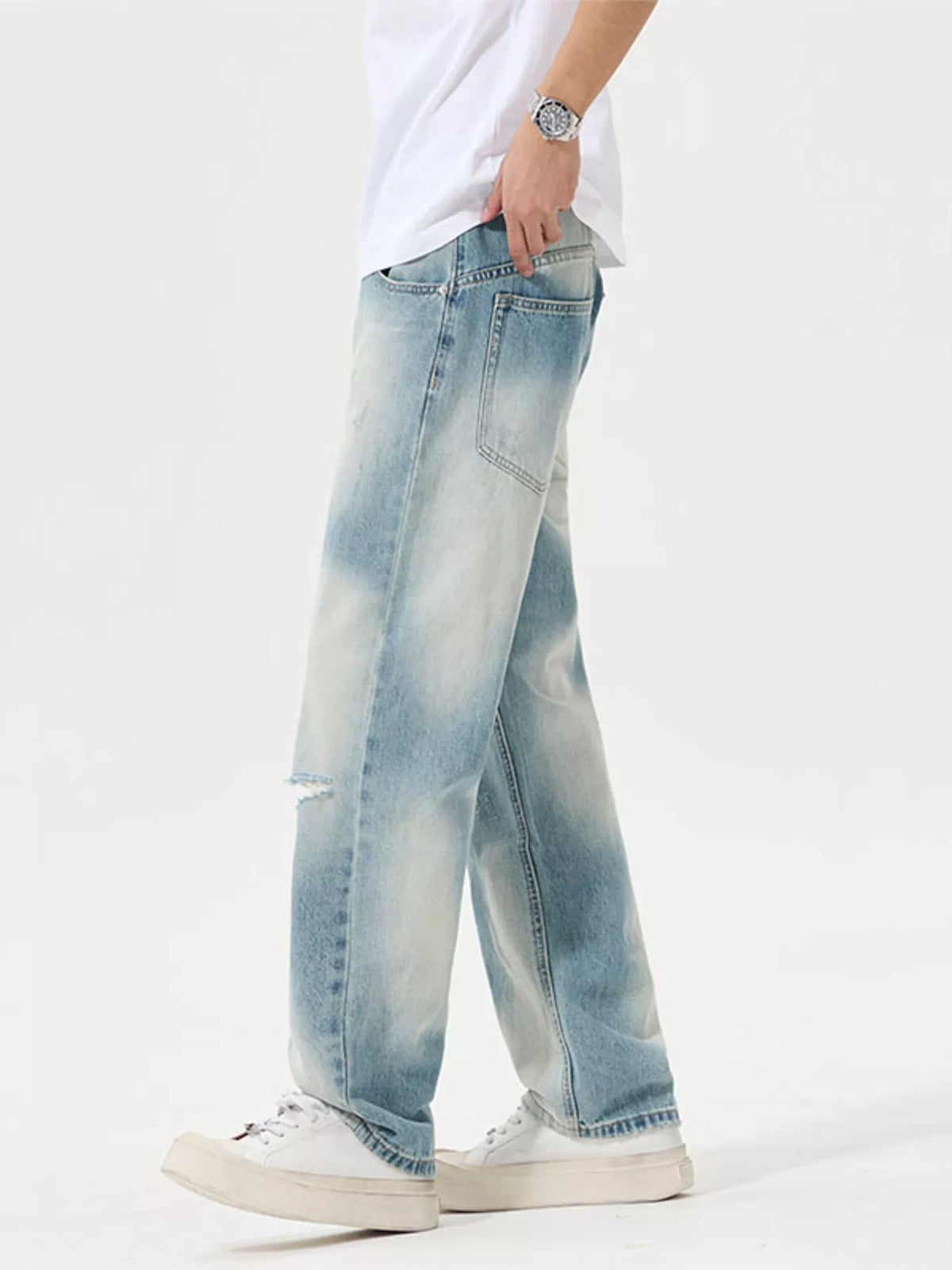 Side view of light-wash relaxed jeans with distressed knee