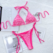 Pink leopard bikini bottoms with side ties laid flat
