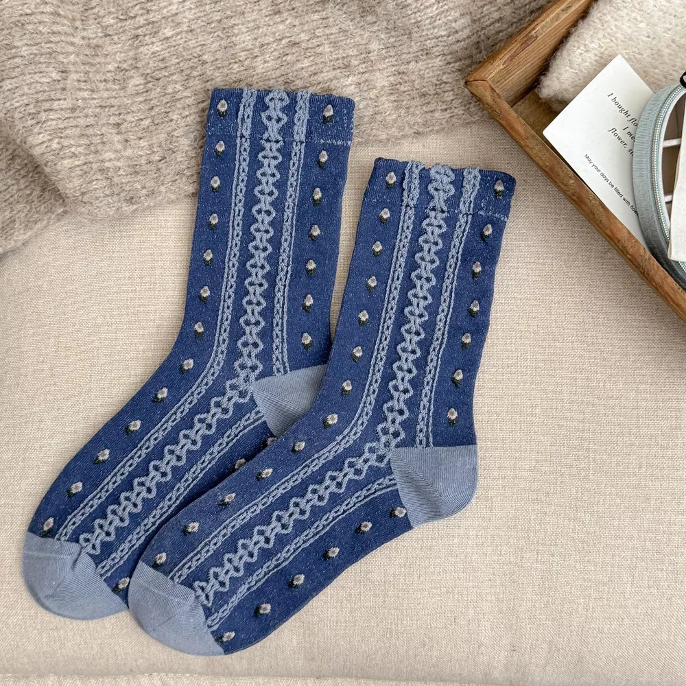 Pair of blue knit socks with gray toes and patterned stripes