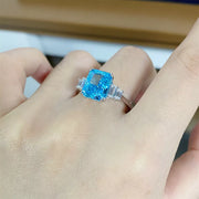 Pastel blue zircon ring worn on a hand, viewed from above
