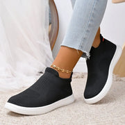 Black slip-on mesh sneakers with white soles, side view
