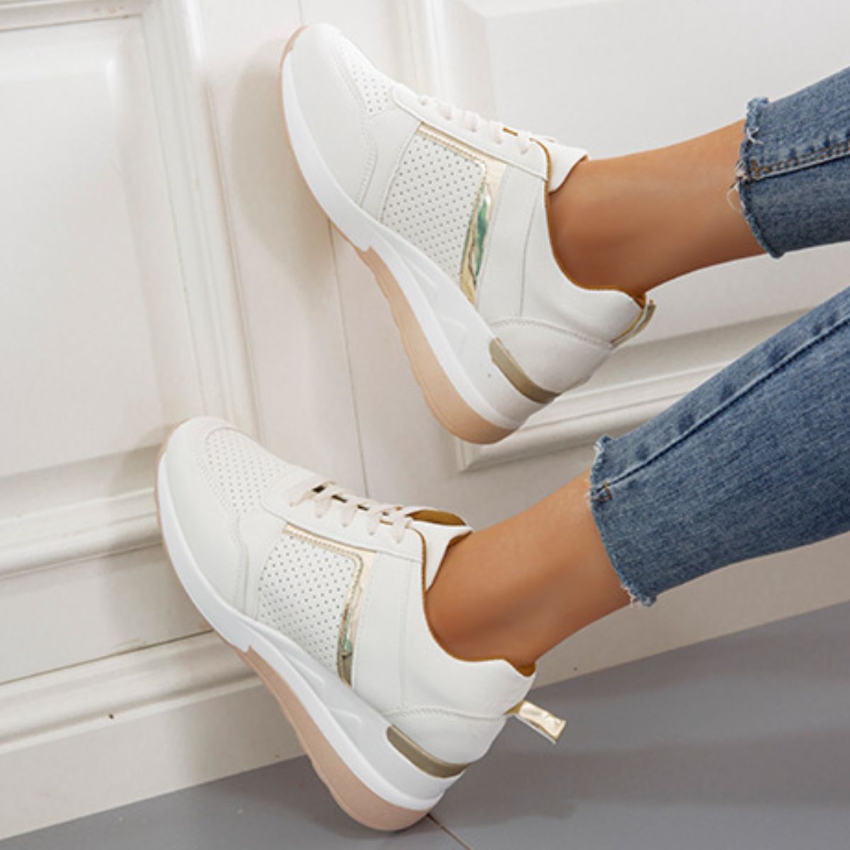 White wedge sneakers worn with jeans, side view
