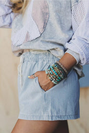 Close side view of the striped shorts pocket and gathered waist.