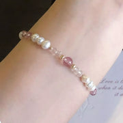 Detail of pale pink and white beads worn on the wrist