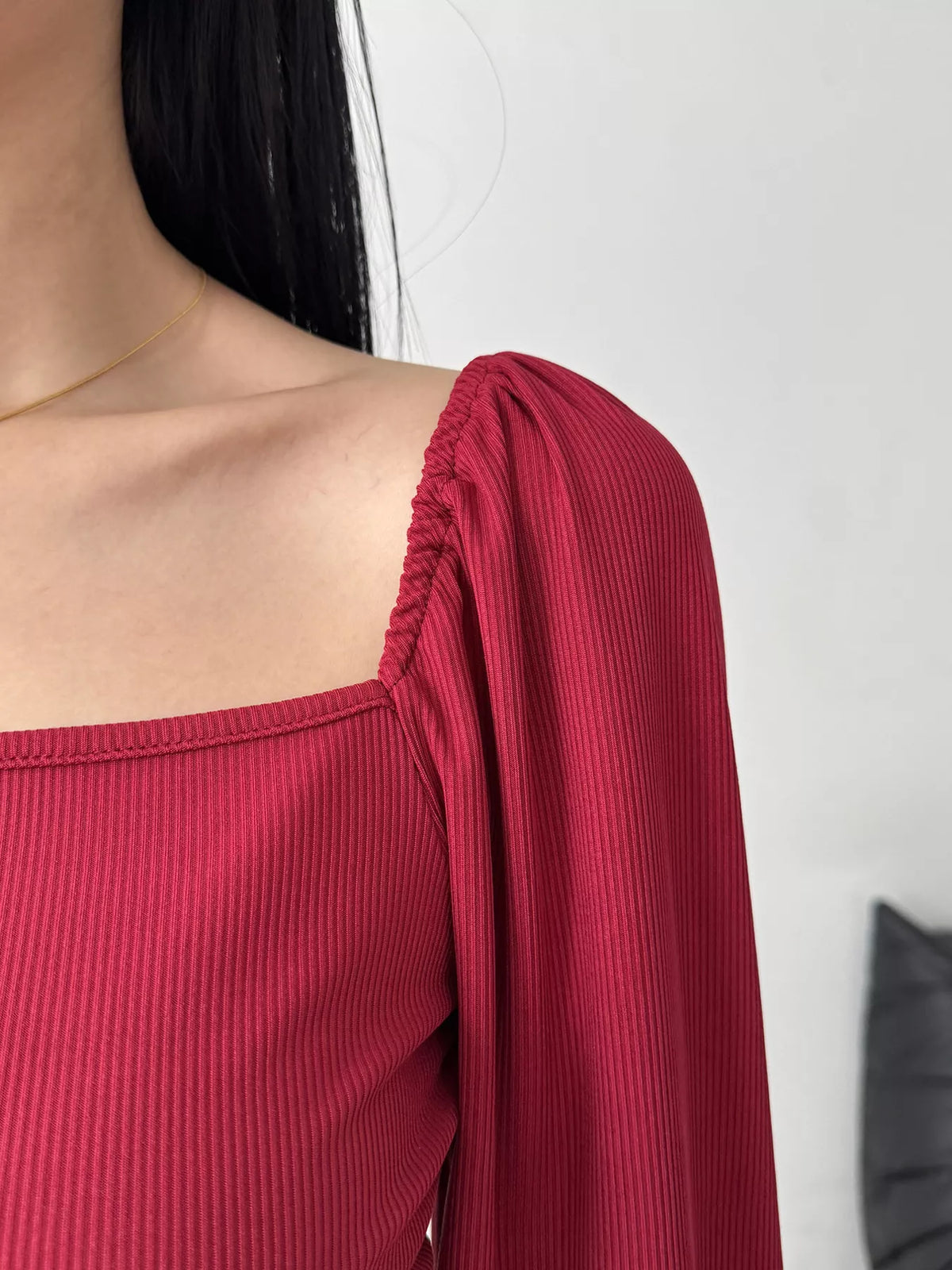 Close-up of gathered sleeve and square neckline on burgundy dress