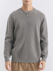 Front view of medium grey ribbed sweater showing long sleeves and straight ribbed hem