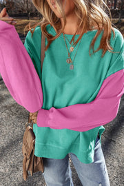 Model wearing turquoise sweatshirt with pink sleeves
