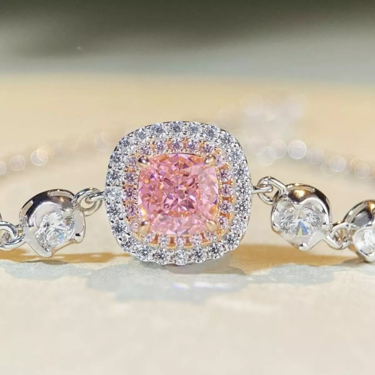 Close-up of the pink square center stone and surrounding clear-stone halo