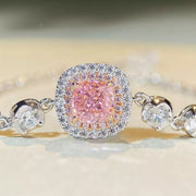 Close-up of the pink square center stone and surrounding clear-stone halo