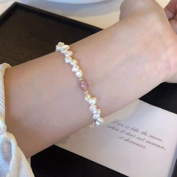 Blush and white pearl bracelet worn on the wrist
