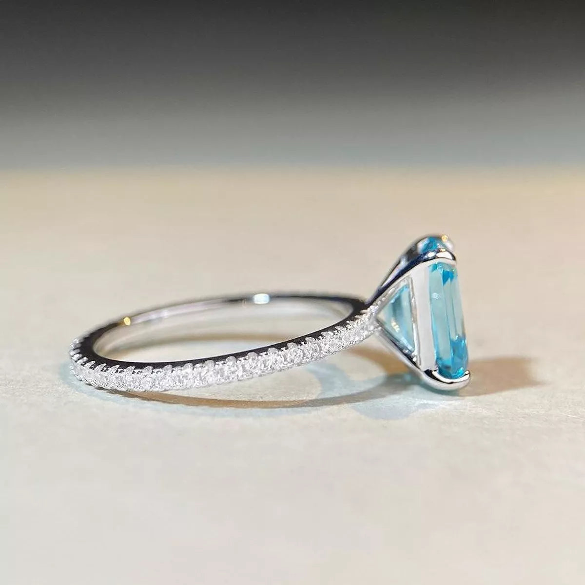 Close-up of the halo setting and pavé band on the silver ring.