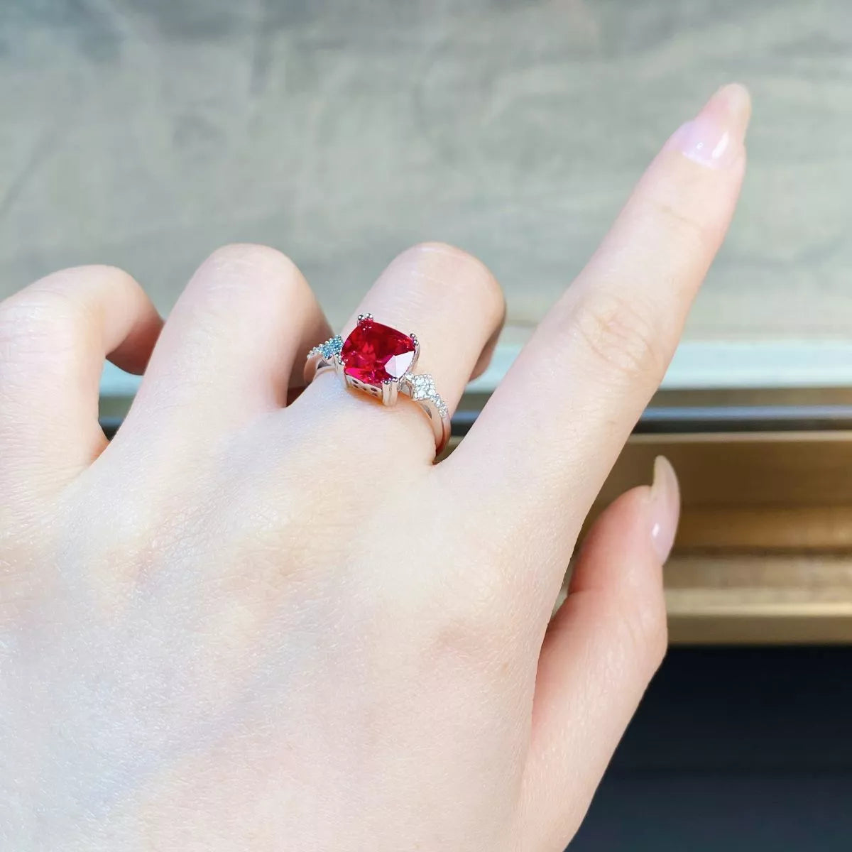 Red centre stone ring shown on a hand from the side.