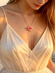 Pink flower Y-shaped lariat necklace worn over a white dress