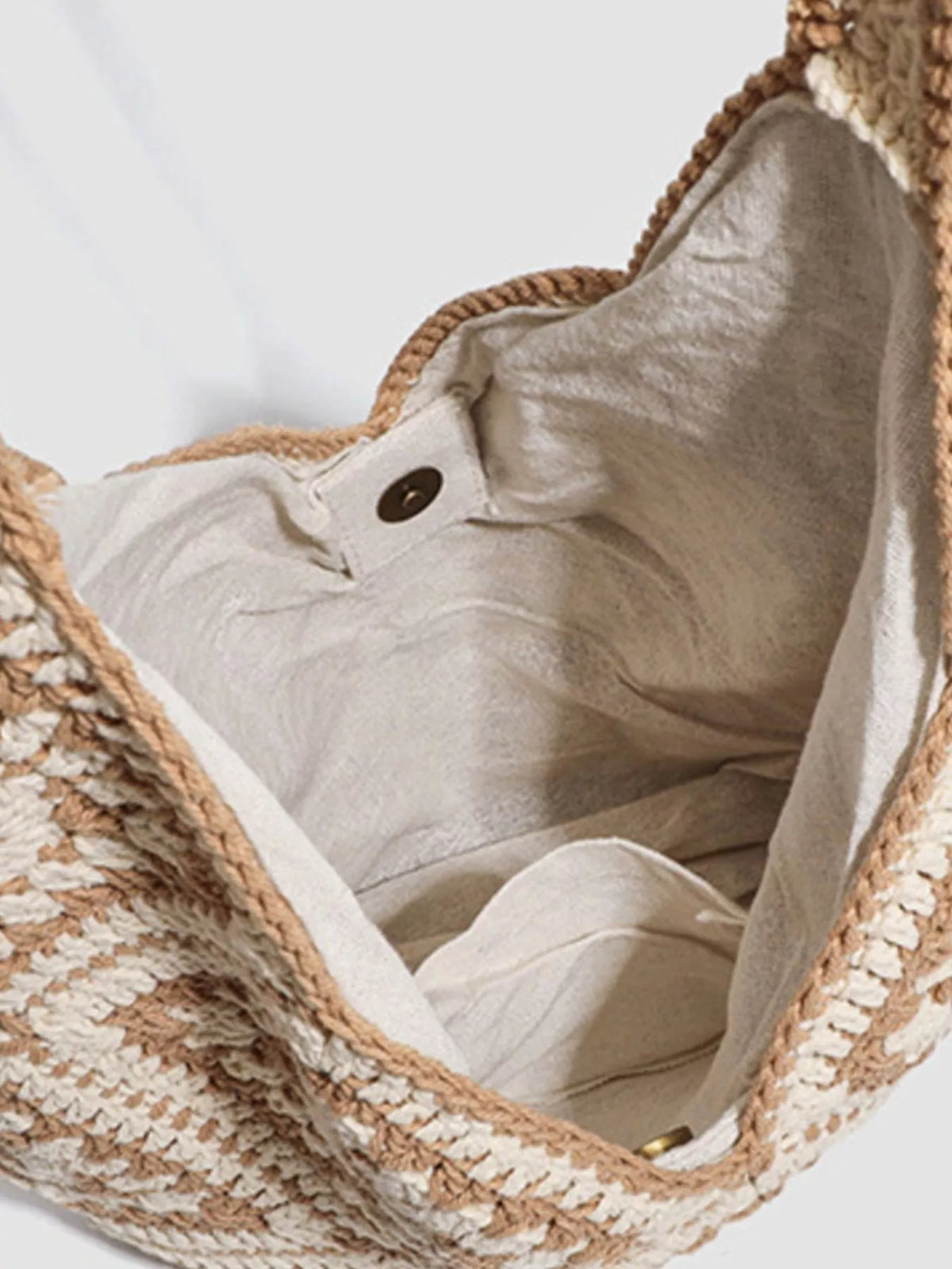 Open crochet bag showing its light fabric lining and magnetic snap
