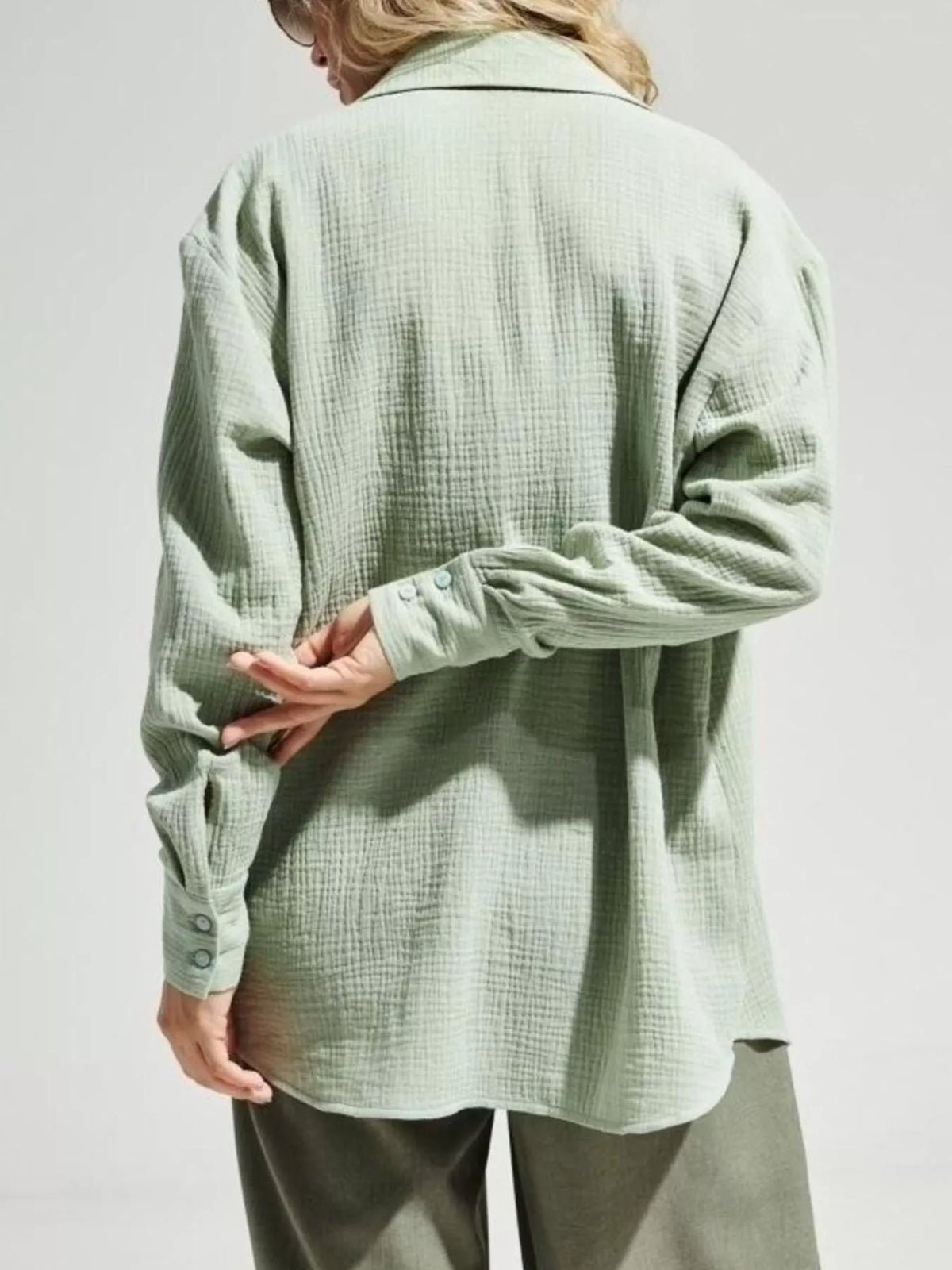 Back view of pale green oversized gauze shirt.