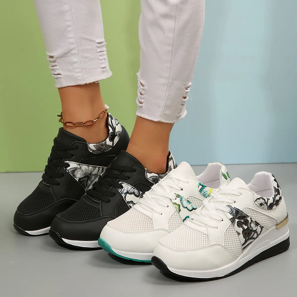 White and black floral sneakers shown together on feet