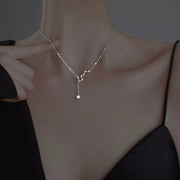 Model wearing a delicate silver star necklace and adjusting the chain