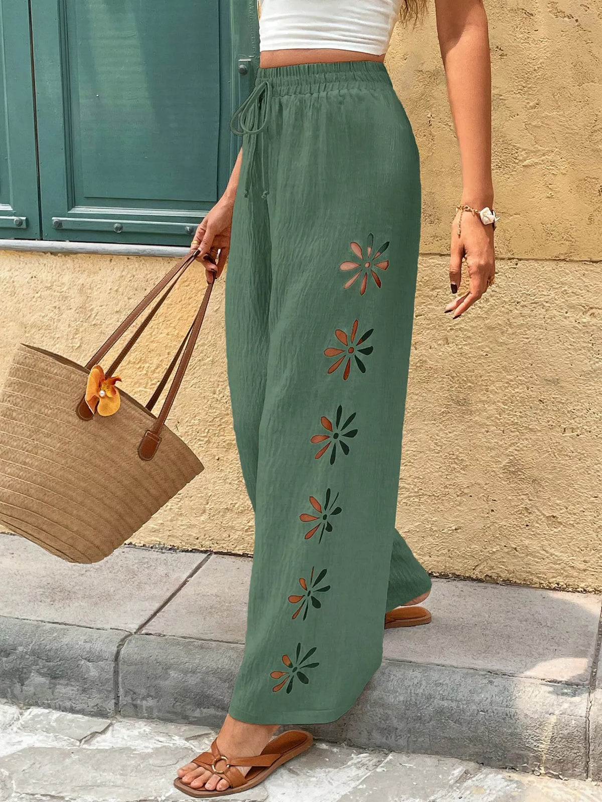 Model wearing sage green wide-leg pants with a white top