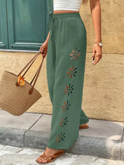 Model wearing sage green wide-leg pants with a white top
