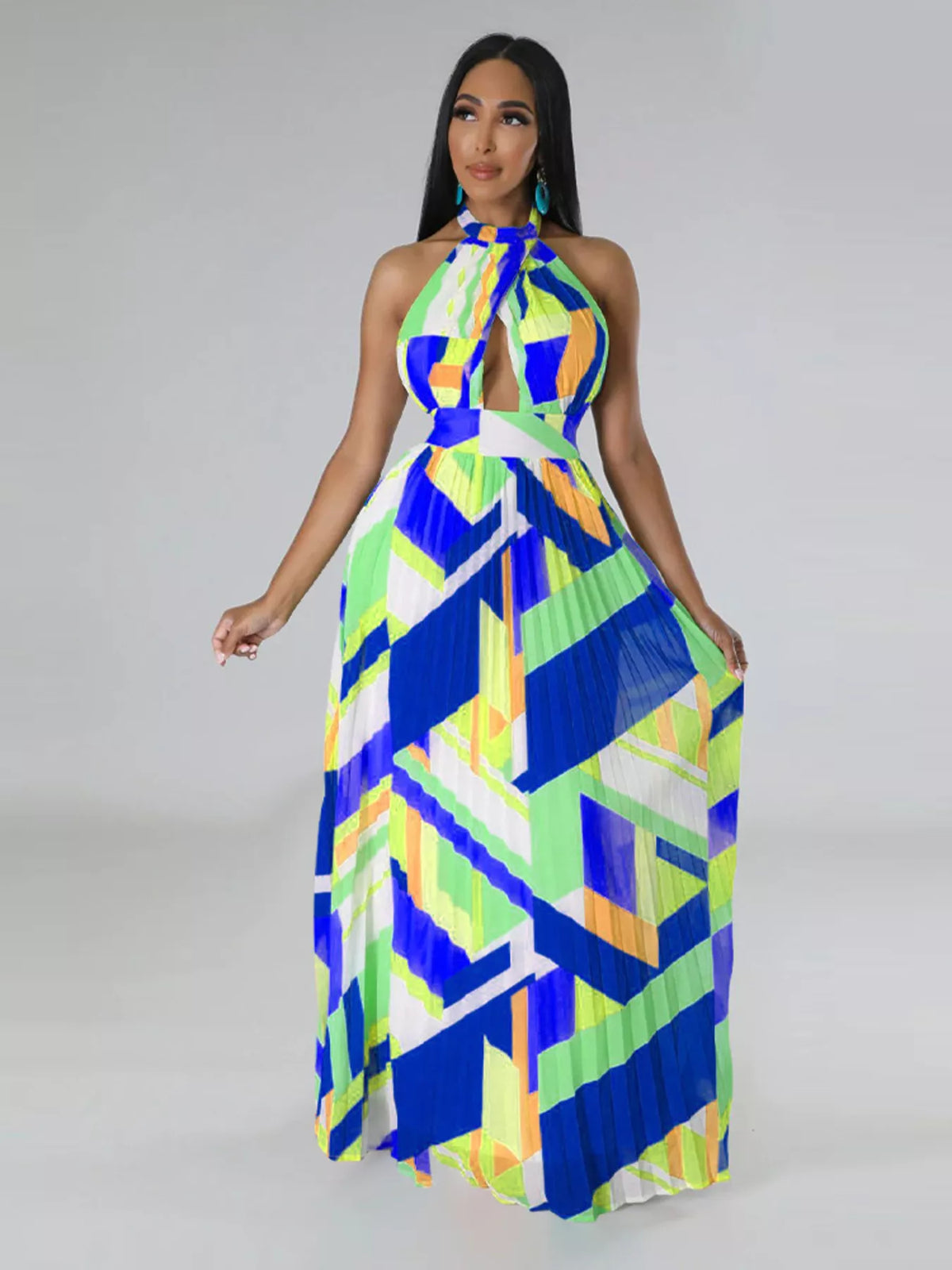 Model holding both sides of the pleated skirt of a blue, lime and white halter maxi dress.