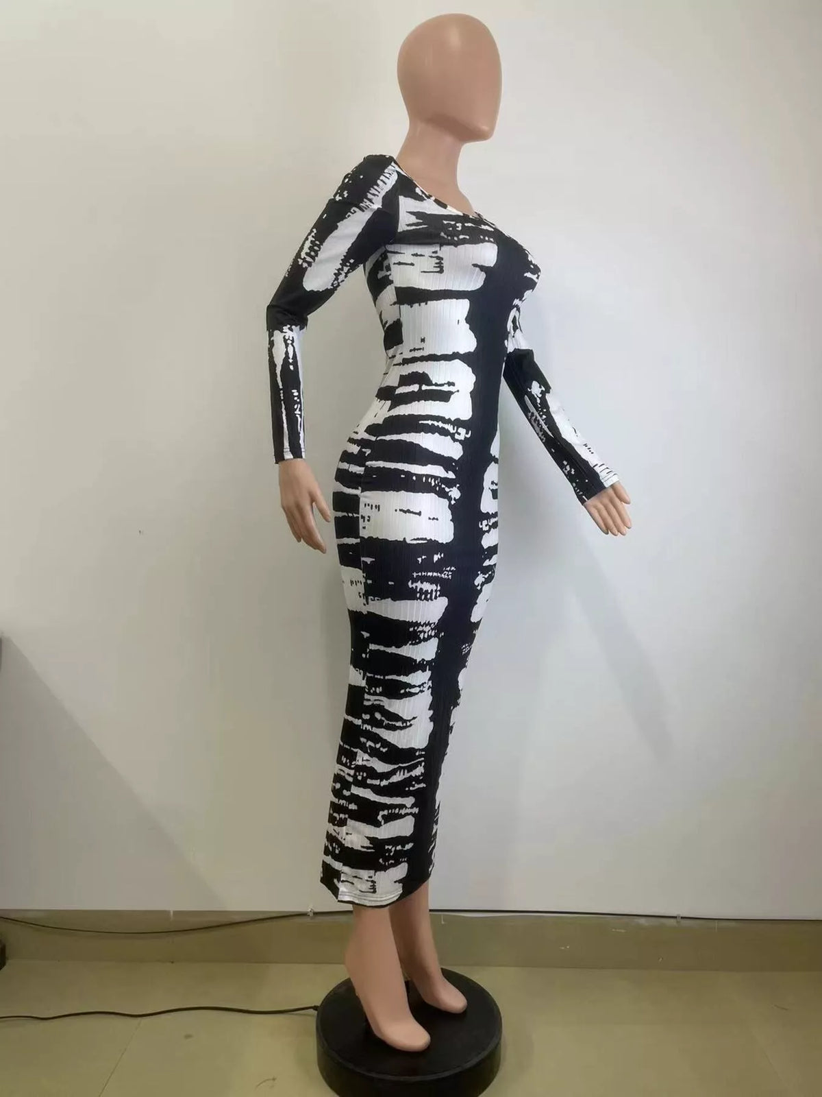 Angled mannequin view of black and white fitted tie-dye maxi dress