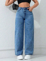 Front view of high-waisted blue wide-leg jeans styled with a black crop top and white trainers