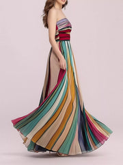 Profile view of multicolor striped strapless pleated maxi dress