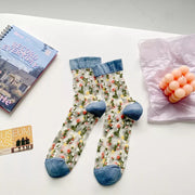 Two floral sheer crew socks with blue cuffs and toes