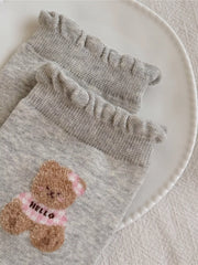Pair of pink bear-print socks laid flat