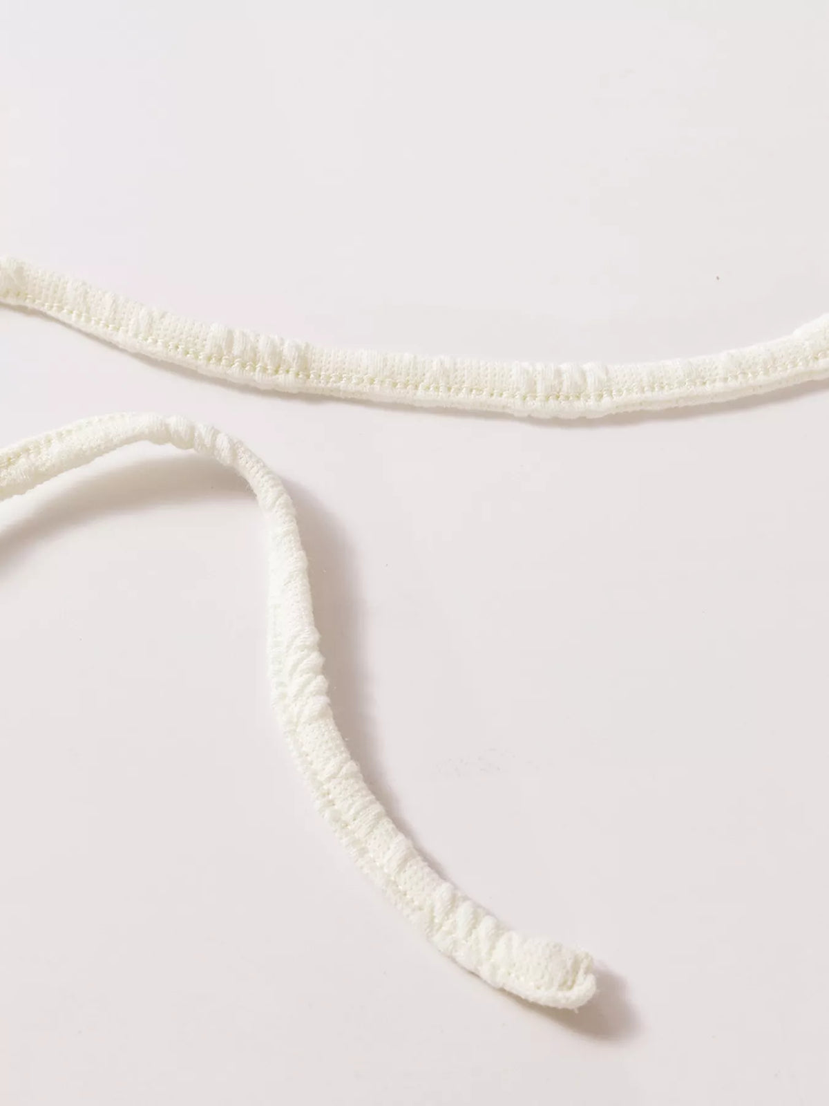 Close-up of textured ivory V-neck trim
