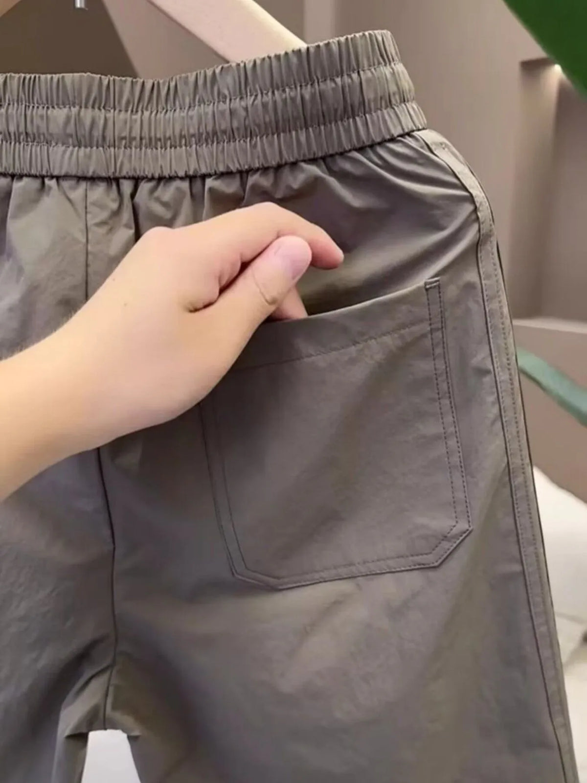 Close-up of the elastic waistband and side pocket on gray shorts