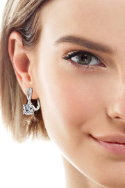 Close-up of a model wearing a silver-tone crossed-loop drop earring