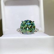 Green-blue round-stone ring displayed in a white jewellery box