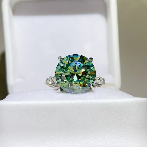 Green-blue round-stone ring displayed in a white jewellery box