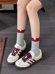Model wearing gray printed crew socks with sneakers