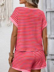 Front view of the coral-pink striped set with the model holding the shirt hem.