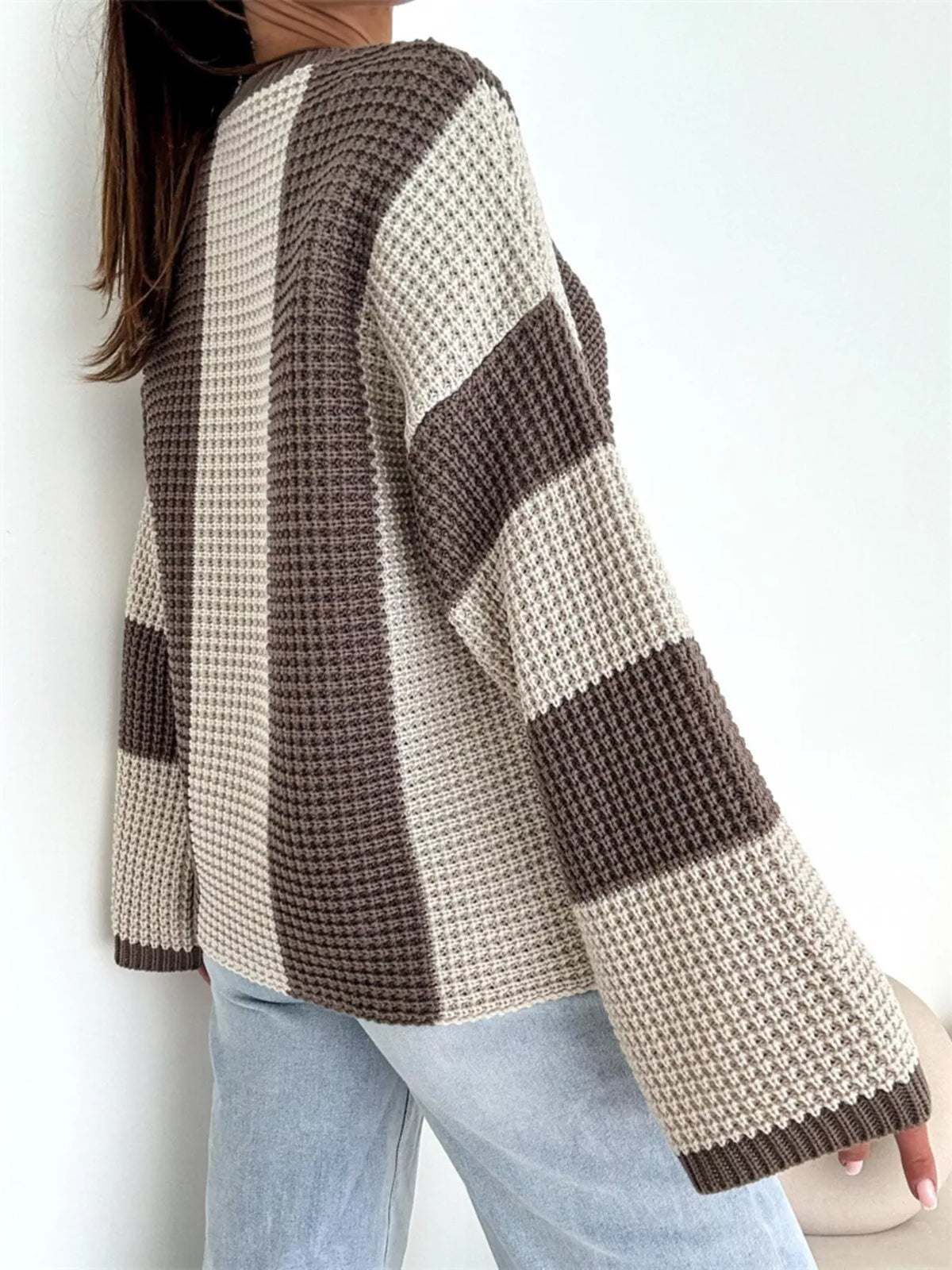 Side view of cream and taupe colour-block sweater with broad sleeve bands