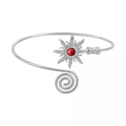 Silver-tone open cuff bracelet with red sunburst centerpiece on white background