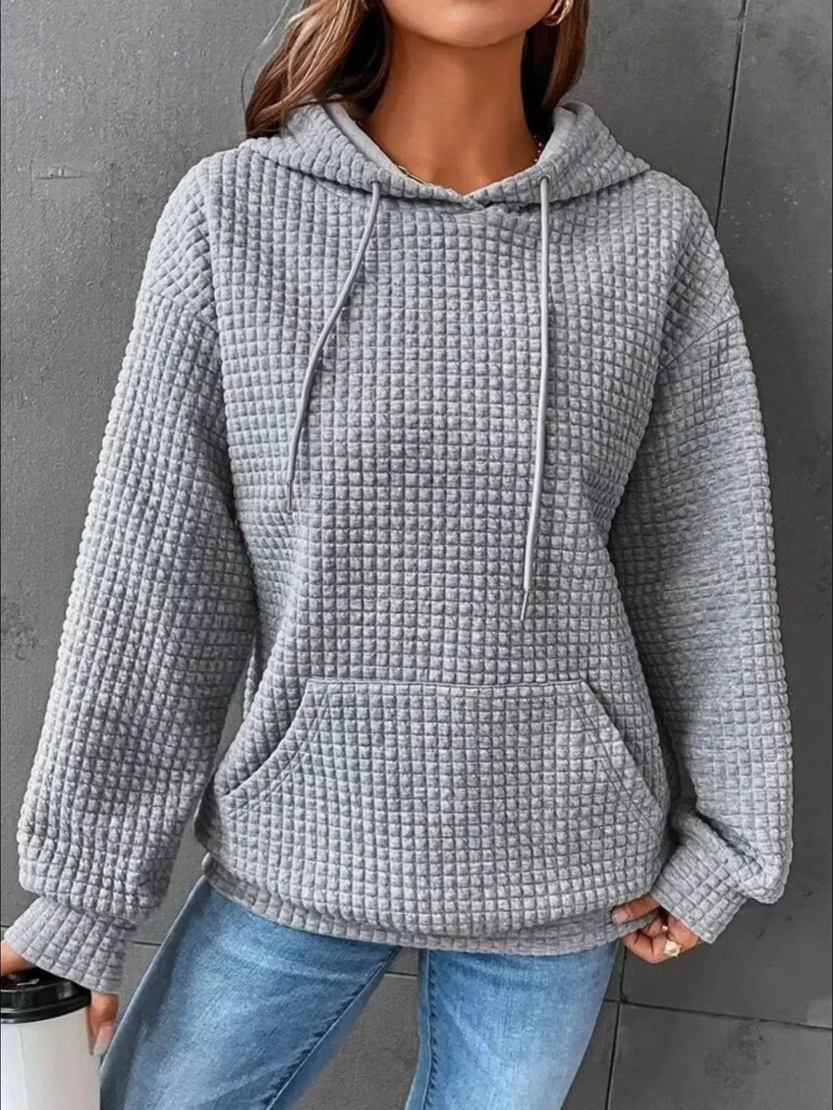 Grey textured hoodie worn with jeans, front view