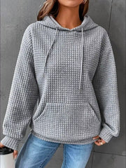 Grey textured hoodie worn with jeans, front view