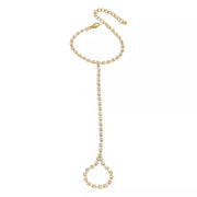 Gold-tone rhinestone bracelet with finger ring displayed on white