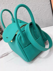 Teal pebbled crossbody bag with long strap draped across the side