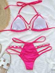 Bright pink cutout halter bikini set laid flat with white-lined cups