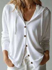 Close view of white hooded cardigan showing buttons and drawstrings